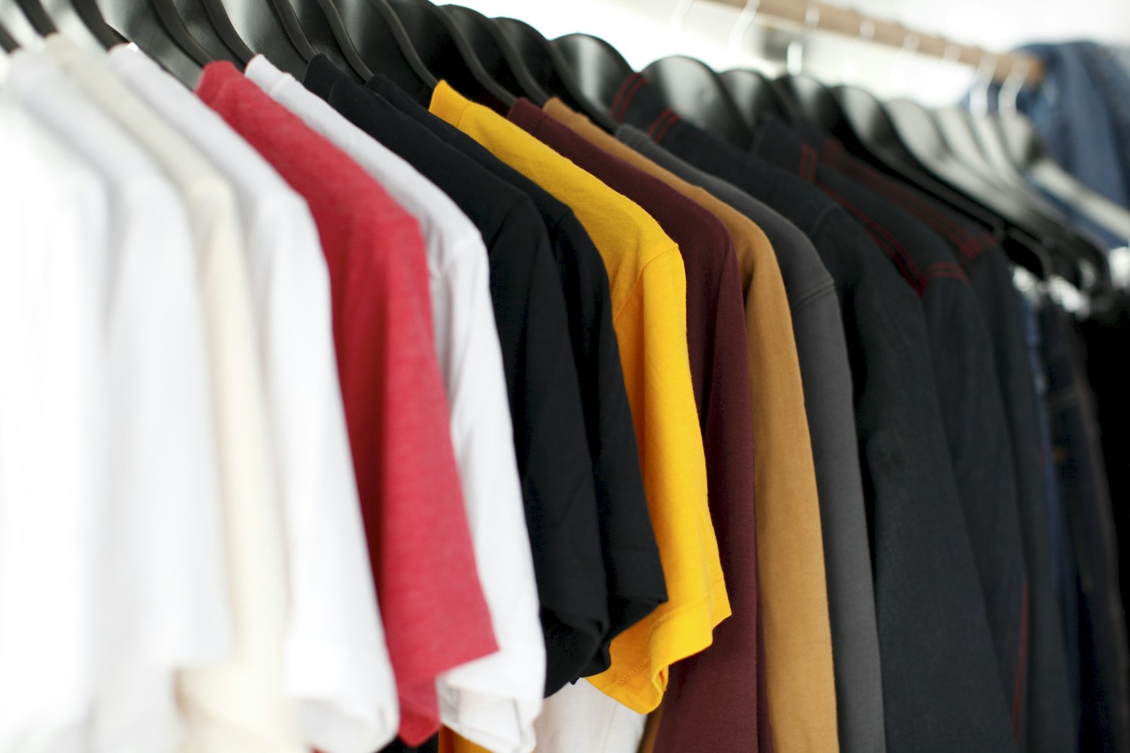 Racks of curated secondhand clothing in a bright resale boutique